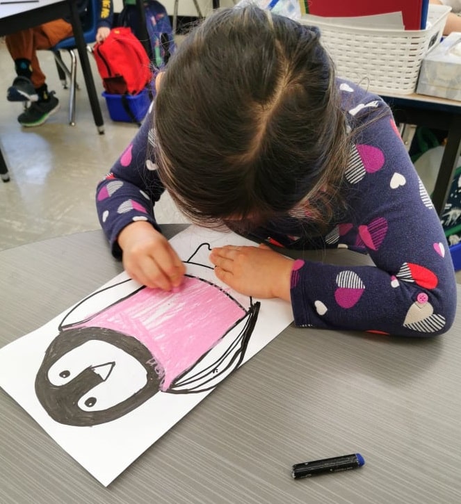 Une élève dessine un pingouin